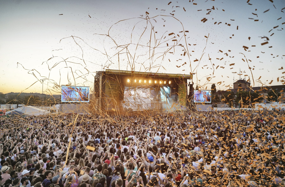 Festivalbühne bei Sonnenuntergang mit vielen Zuschauern
